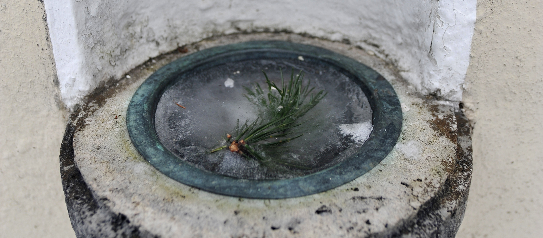 Gefrohrenes Weihwasser mit einem Tannenzweig drin.