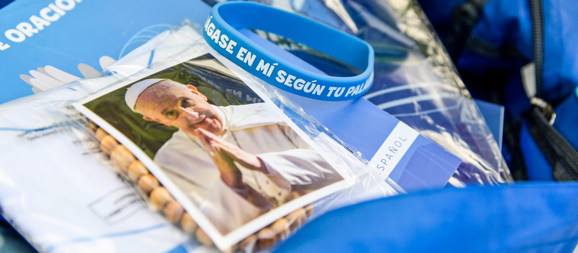 Jeder Pilger bekommt ein PilgrimKit mit Rosenkranz aus Holz, blauer Kappe und Foto von Papst Franziskus.
