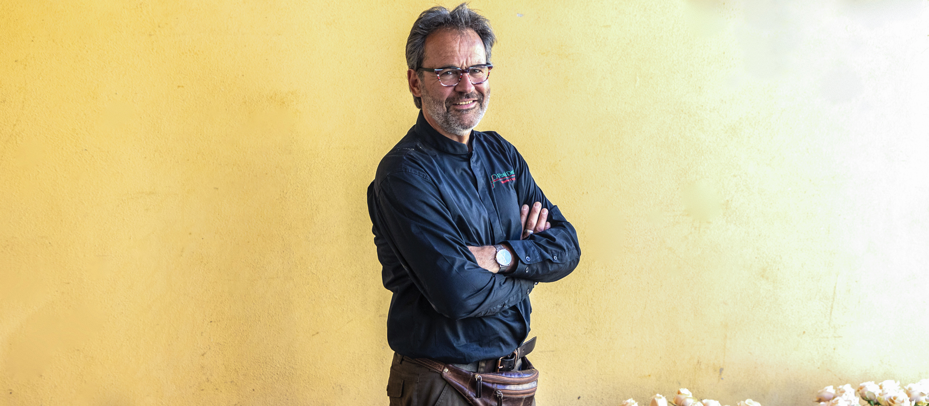 Blumendesigner Paul Deckers steht mit verschränkten Armen vor einer Wand