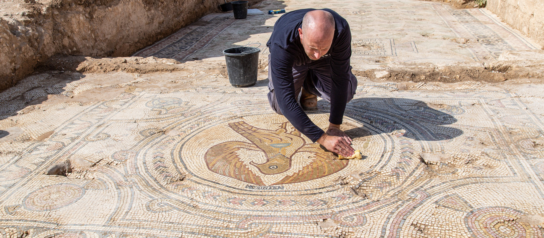 Ein Archäologe reinigt Mosaike der Kirche aus byzantinischer Zeit in Bet Schemesch mit einem Schwamm.