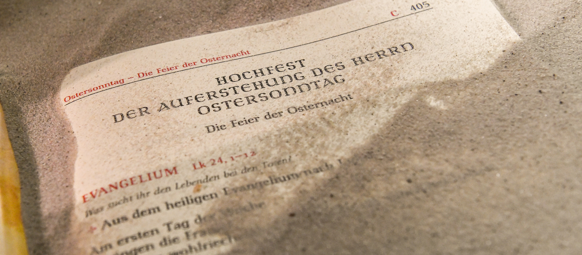 Ein Evangeliar liegt im Sand