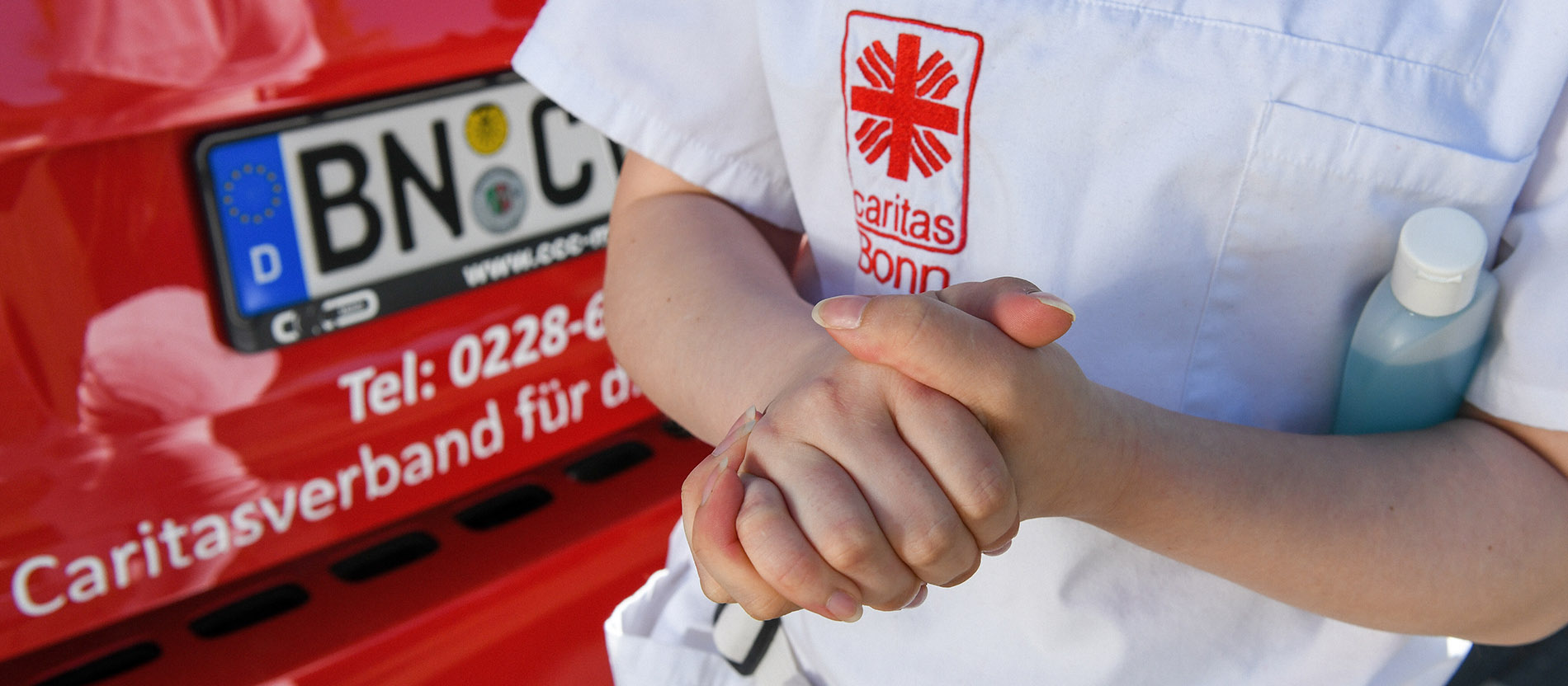 Pflegerin desinfiziert ihre Hände