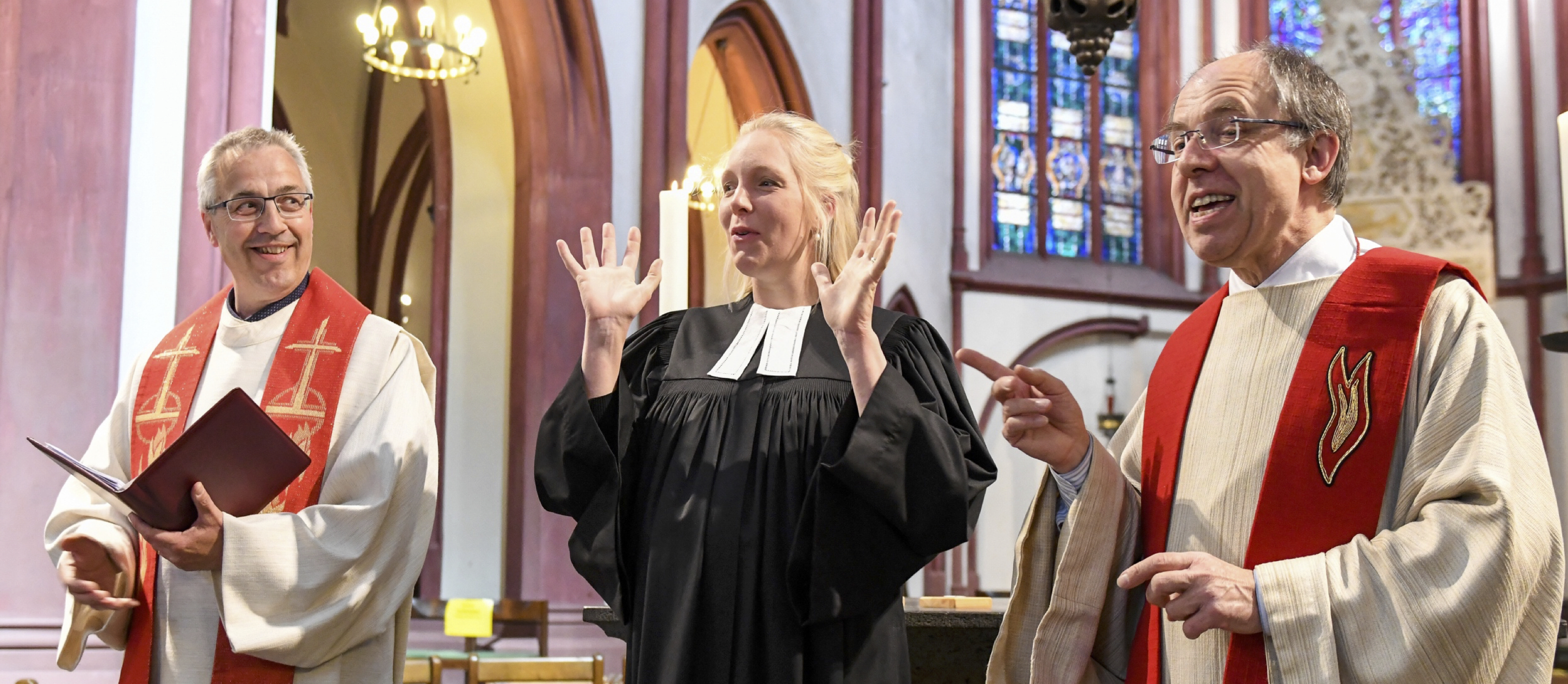 Ein altkatholischer Priester, eine evangelische Pfarrerin und ein katholischer Priester stehen nebeneinander