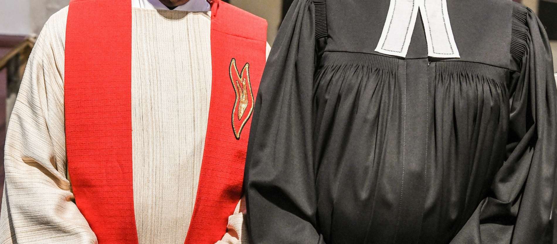 Ein Priester und eine evangelische Pfarrerin stehen nebeneinander