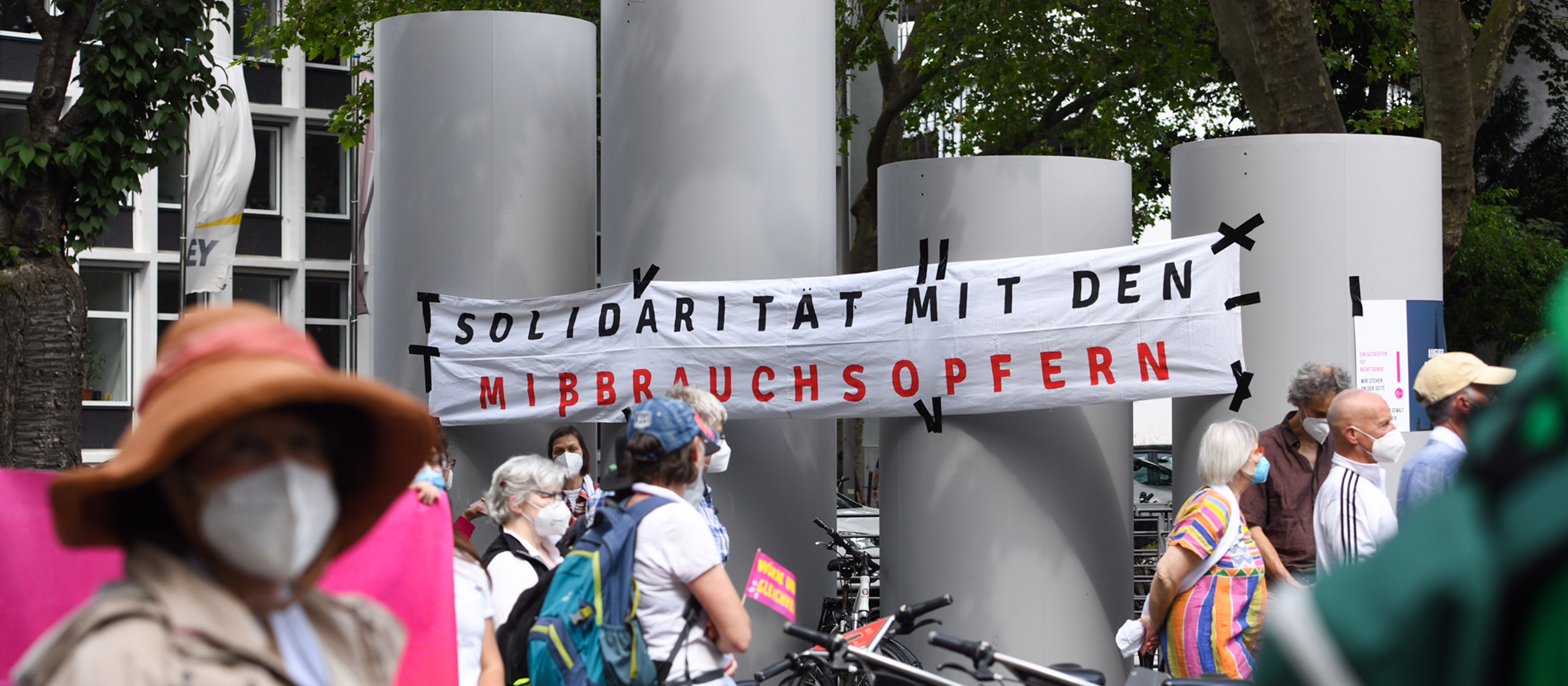 Eine Demonstration in Köln, im Hintergrund ein Plakat mit der Aufschrift 