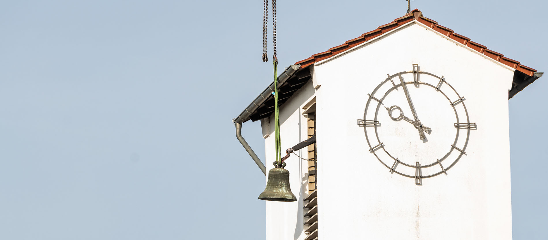 Eine Glocke wird mit einem Kran aus einem Kirchturm gehoben