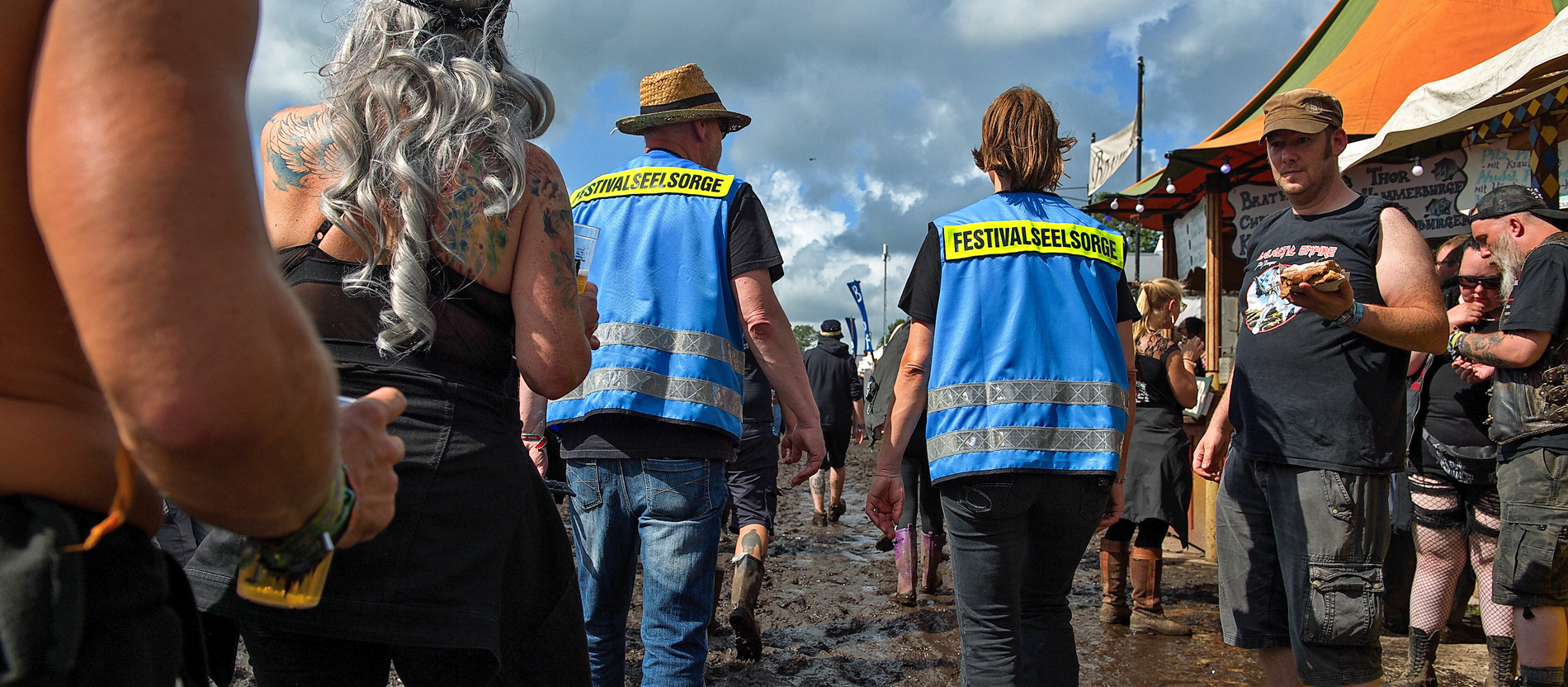 Zwei Festivalseelsorger gehen durch den Schlamm auf dem Gelände beim Wacken Open Air Festival