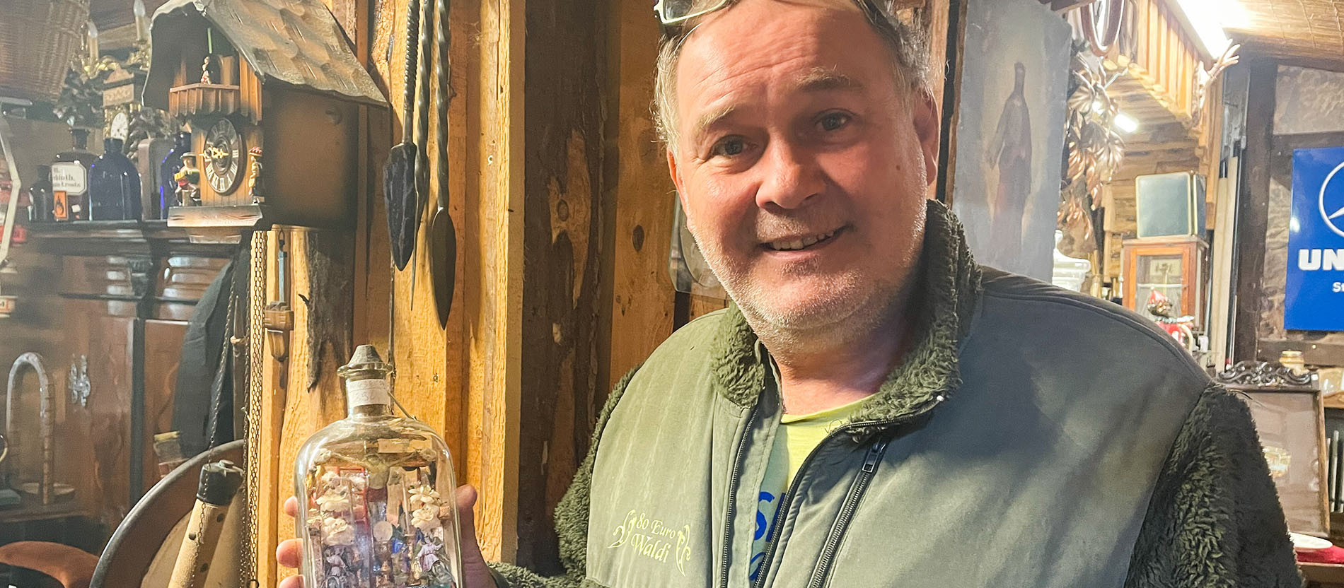 Walter "Waldi" Lehnertz mit einem antiken Mini-Altar in einer Flasche in seinem Ladenlokal "Eifel-Antik" in Kall-Krekel