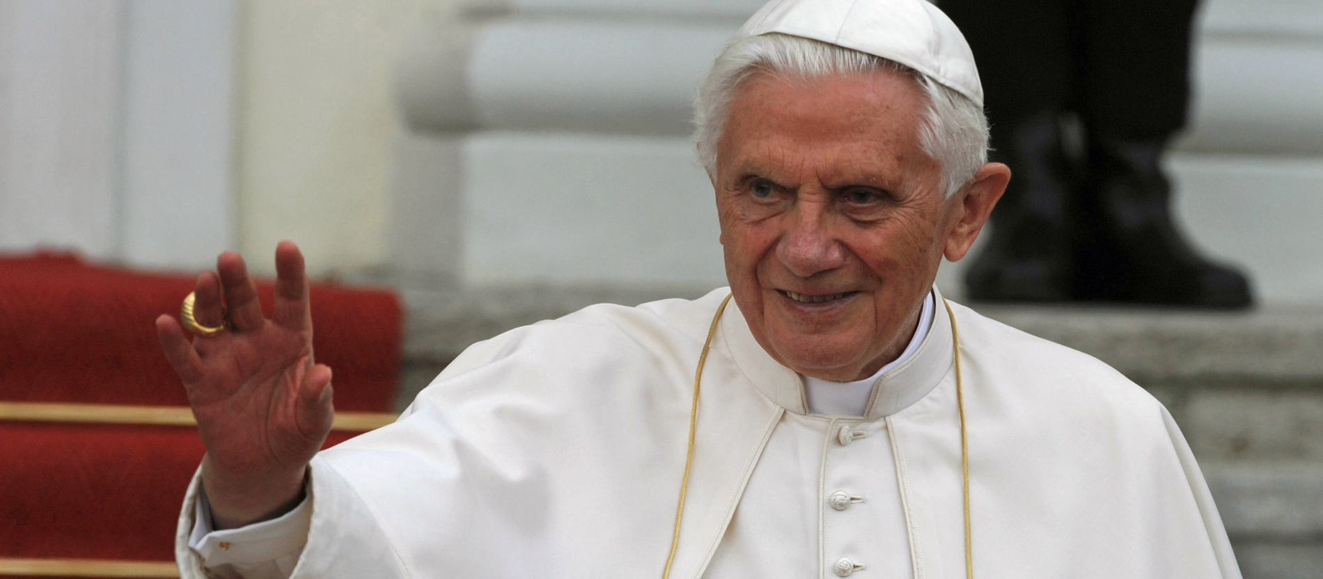 Papst Benedikt XVI. winkt fröhlich den Gläubigen zu.