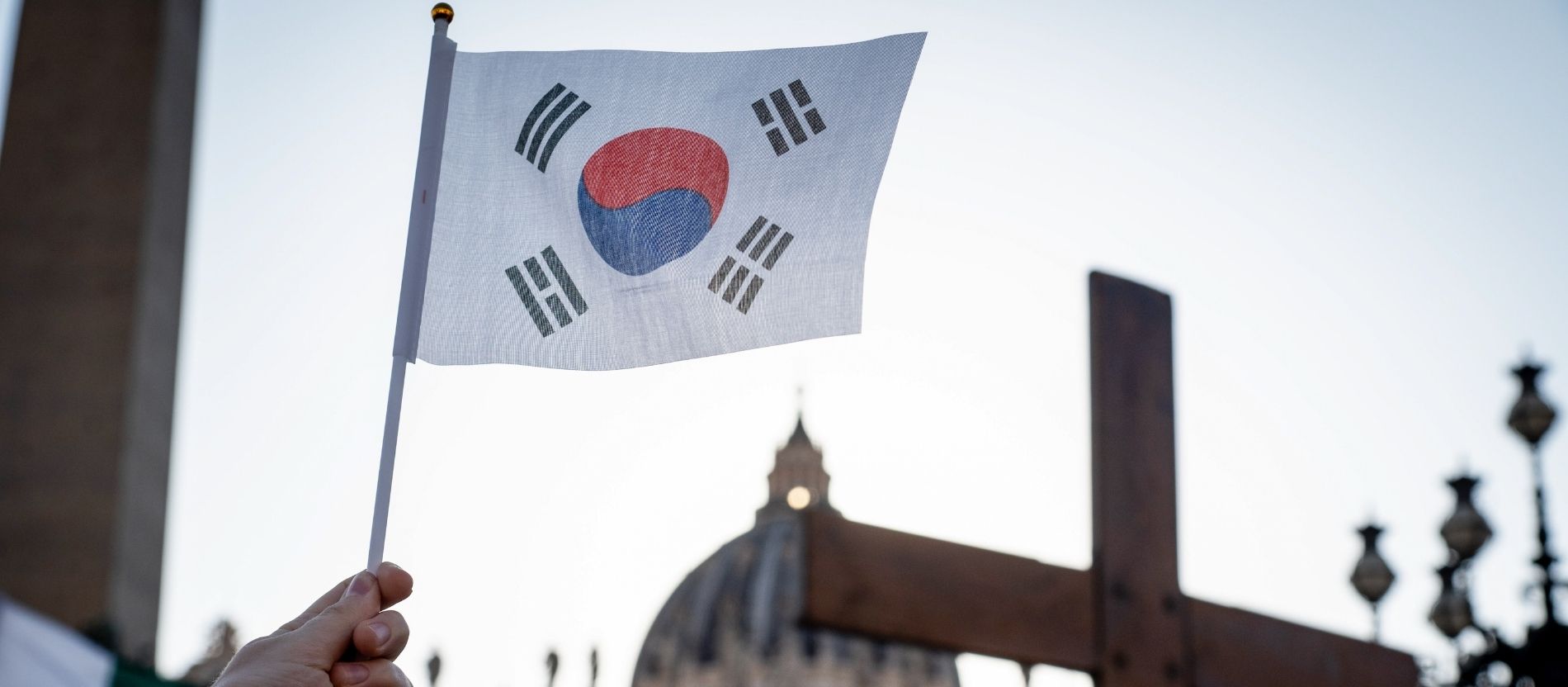 Fahne von Südkorea und Weltjugendtagskreuz vor dem Petersdom
