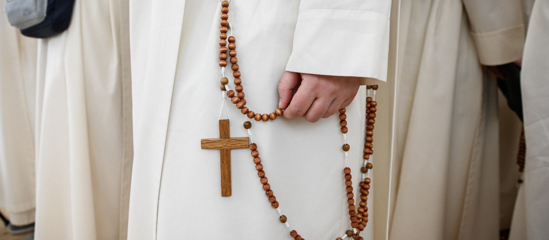 Eine Dominikanerin in weißem Habit hält einen Rosenkranz in der Hand