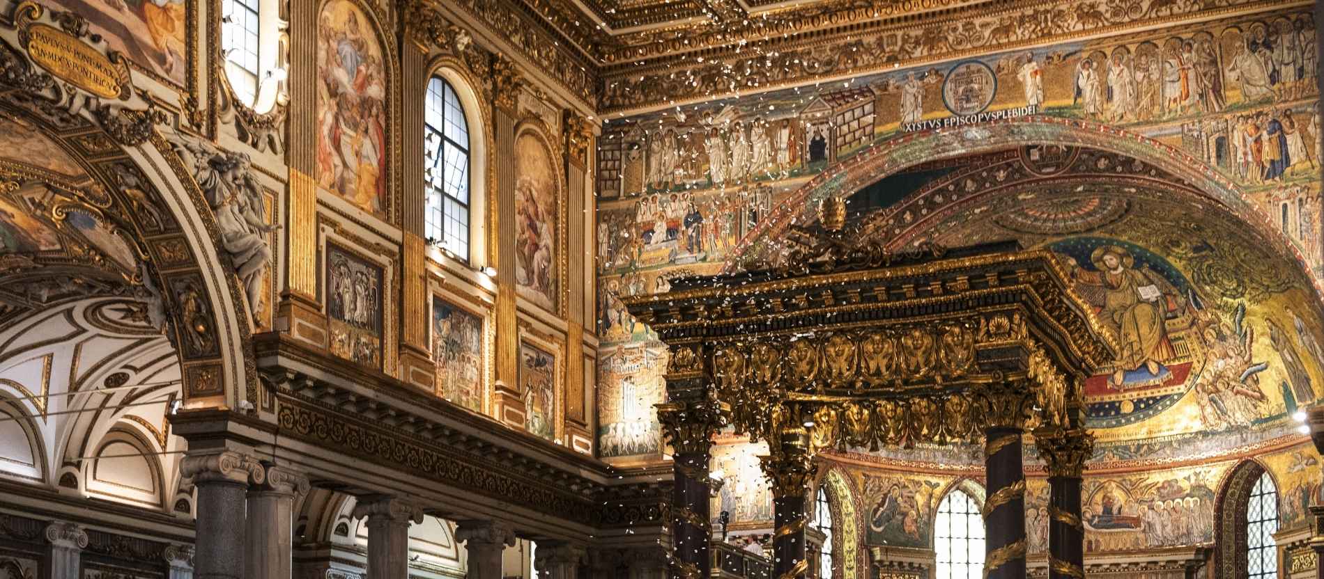 Weiße Blütenblätter rieseln von der vergoldeten Kassettendecke der Basilika Santa Maria Maggiore