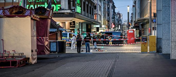 Einsatzkräfte der Polizei hinter einem Absperrband am Abend des 3. März 2025 nach einer Amokfahrt am Paradeplatz in Mannheim