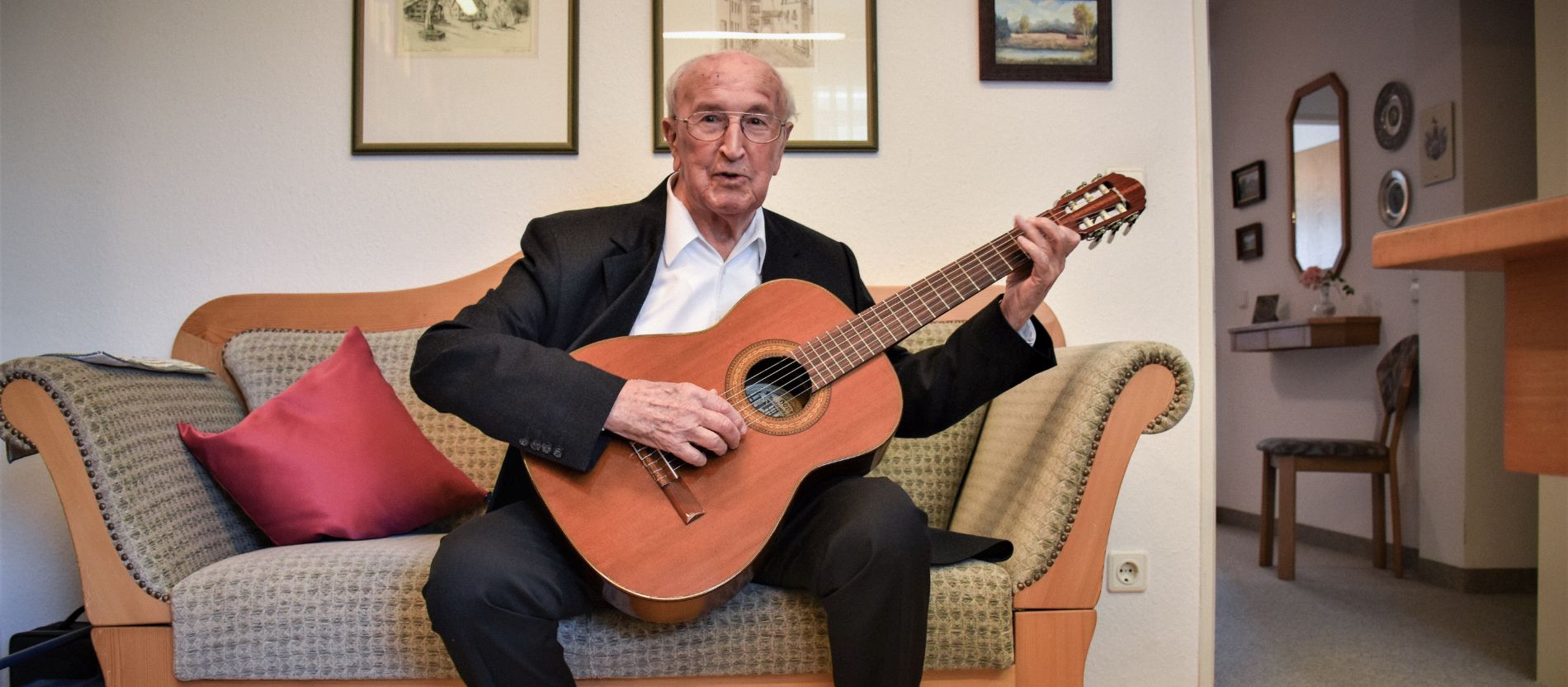 Priester Max Knorr spielt Gitarre
