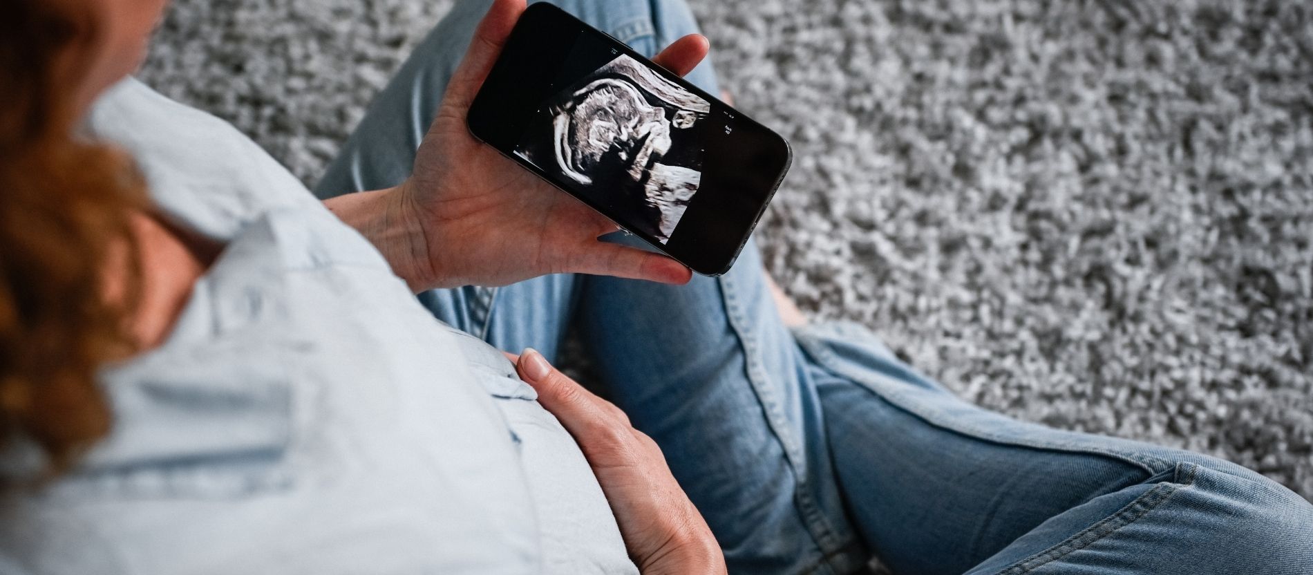 Schwangere guckt sich ein Ultraschallbild ihres Kindes an