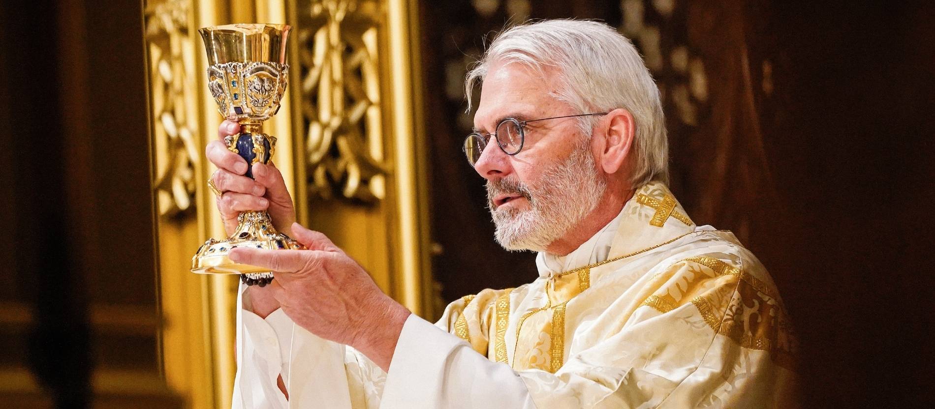 Erzbischof Paul Coakley erhebt bei einer Eucharistiefeier den Kelch
