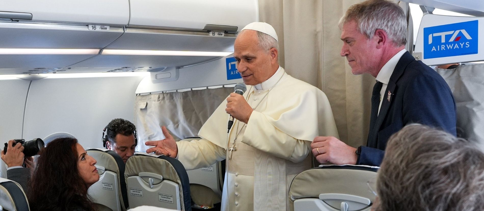 Papst Leo XIV. und Matteo Bruni im Flugzeug beim Gespräch mit einer Journalistin