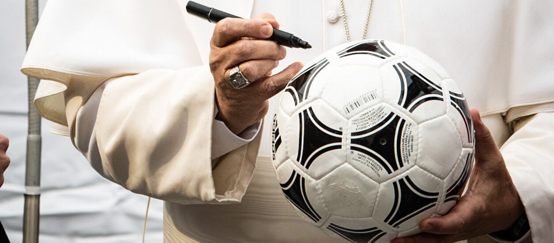 Papst Leo XIV. hält einen schwarzen Filzstift und einen Fußball in der Hand