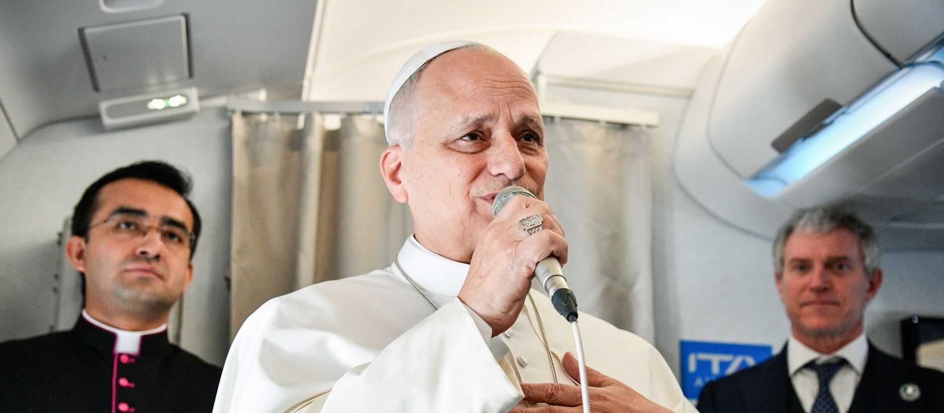 Papst Leo XIV. spricht in einem Flugzeug in ein Mikrofon