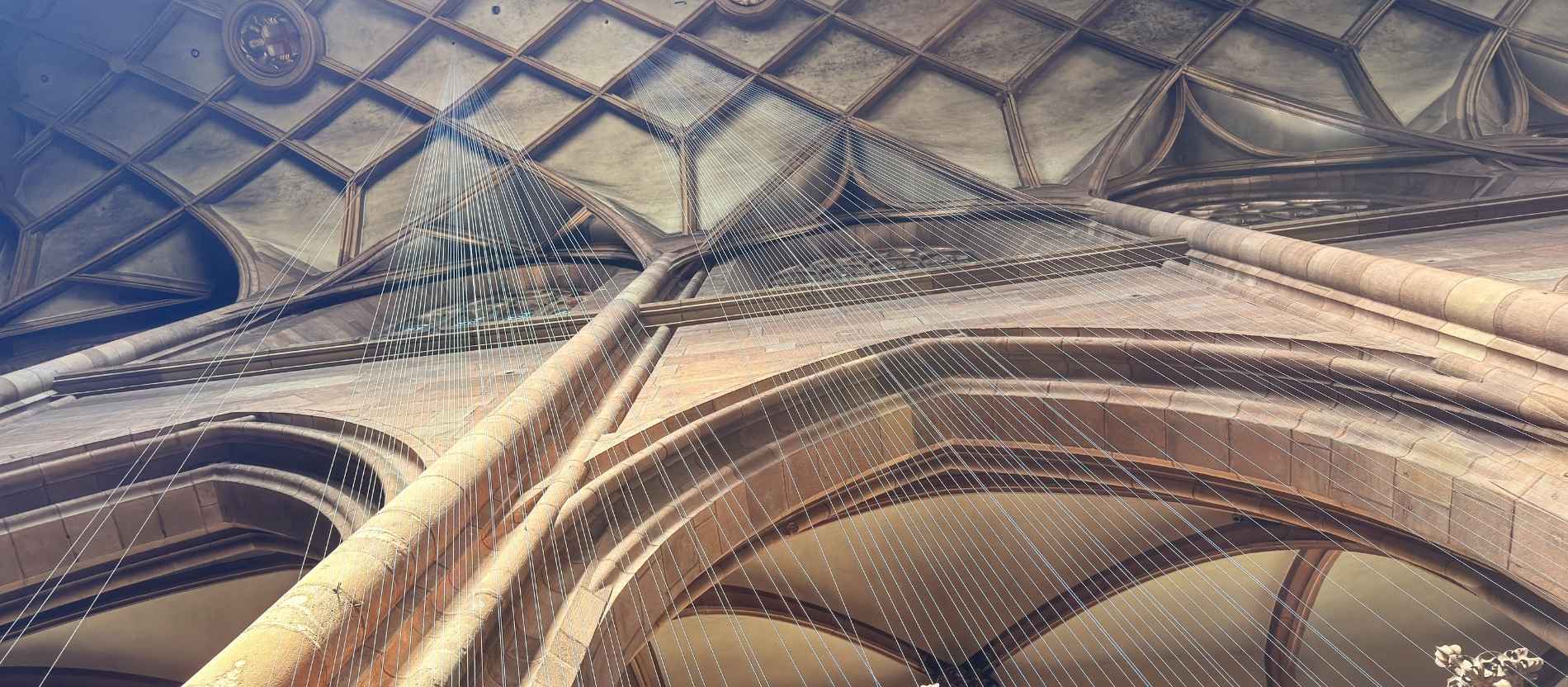 Lange Fäden hängen von der Decke im Freiburger Münster. 