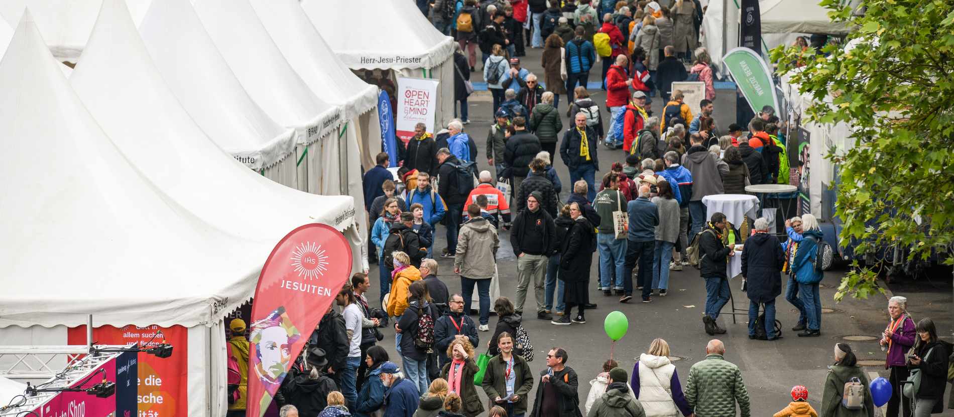 Menschen vor und zwischen den Zelten auf der Kirchenmeile beim 104. Katholikentag am 14. Mai 2026 in Würzburg.