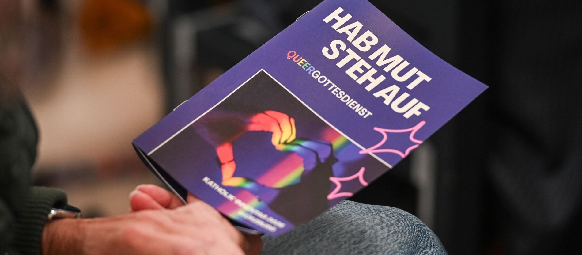 Hände mit Programmheft beim Gottesdienst zu 