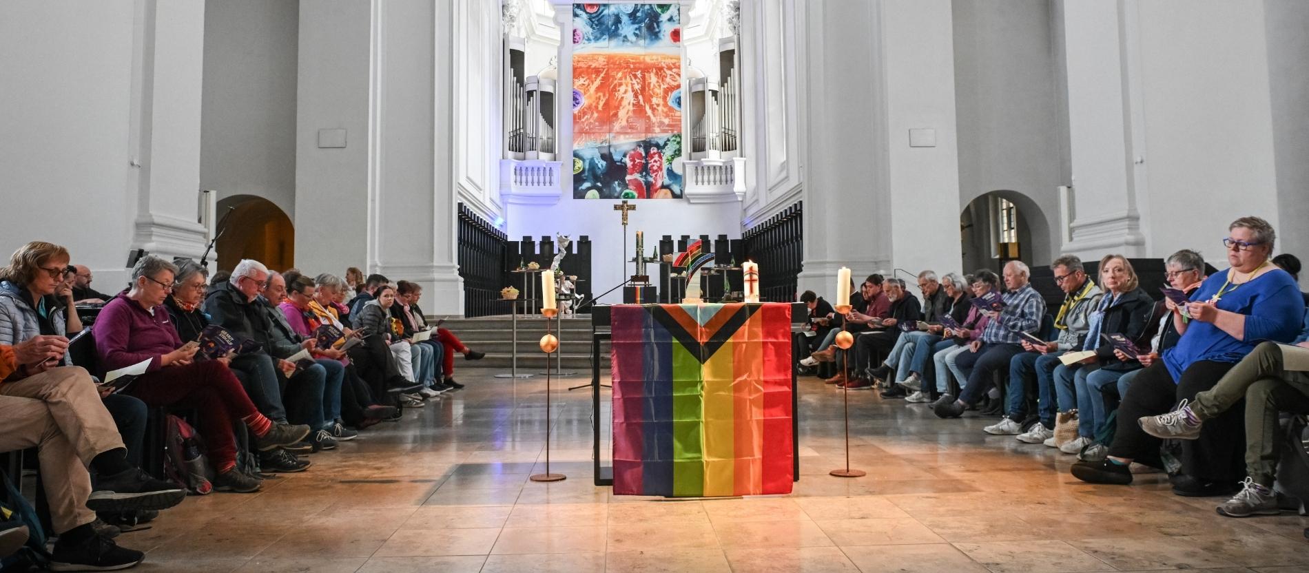Regenbogenfahne am Altar bei einem Queergottesdienst
