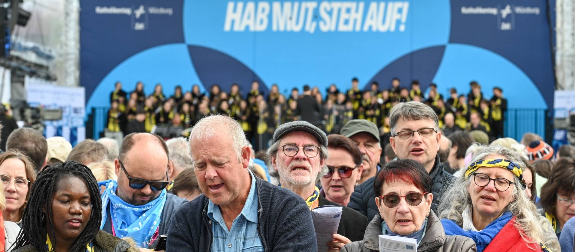Teilnehmer singen beim Abschlussgottesdienst auf dem Katholikentag in Würzburg.