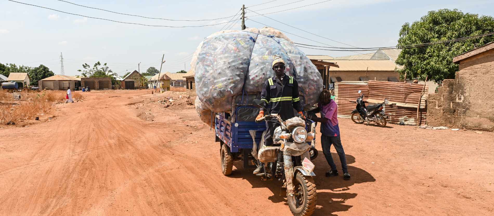 Yaro Seidu auf seinem Lastenmotorrad mit Plastikflaschen, am 26. März 2026 auf einer Sandpiste in Tamale (Ghana).