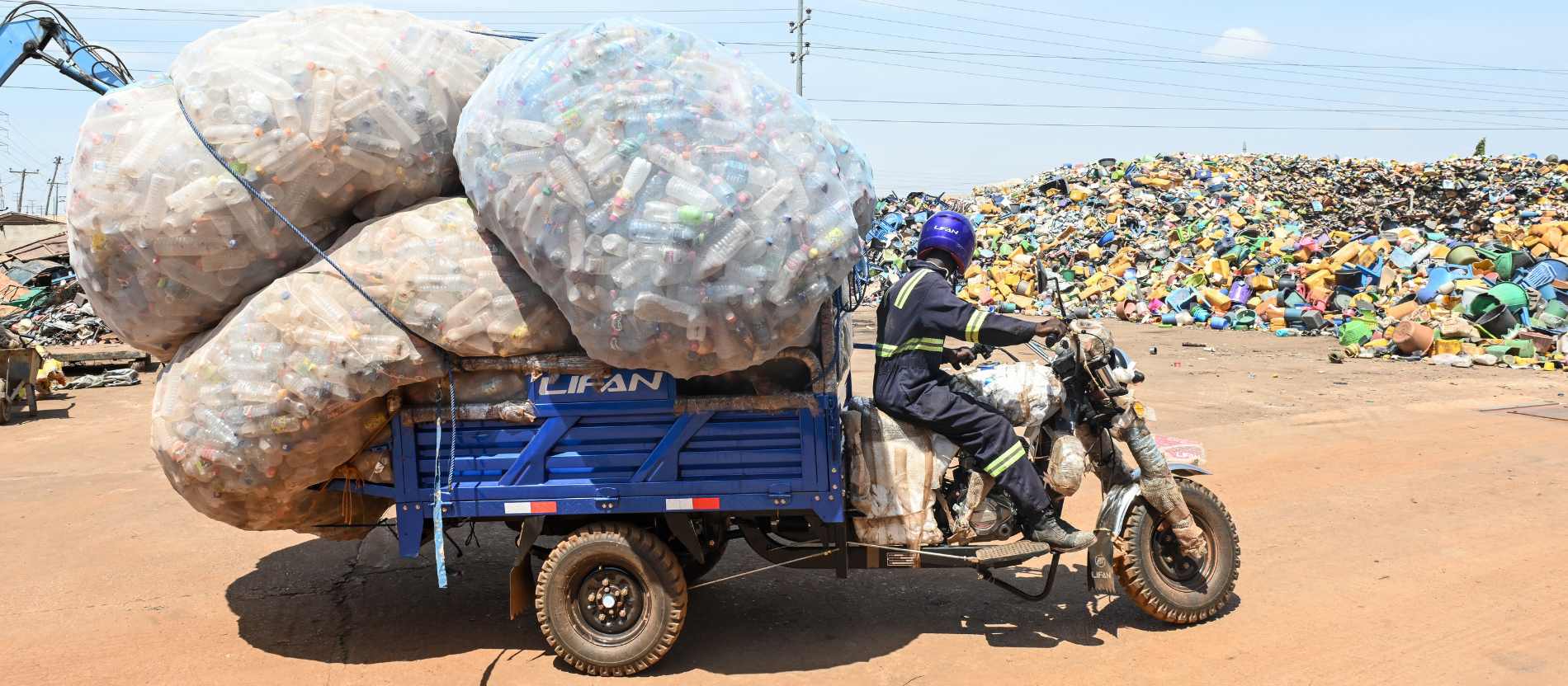 Yaro Seidu rangiert mit seinem Lastenmotorrad mit rund 200 Kilo Plastikflaschen am 26. März 2026 auf dem Recyclinghof in Tamale (Ghana).