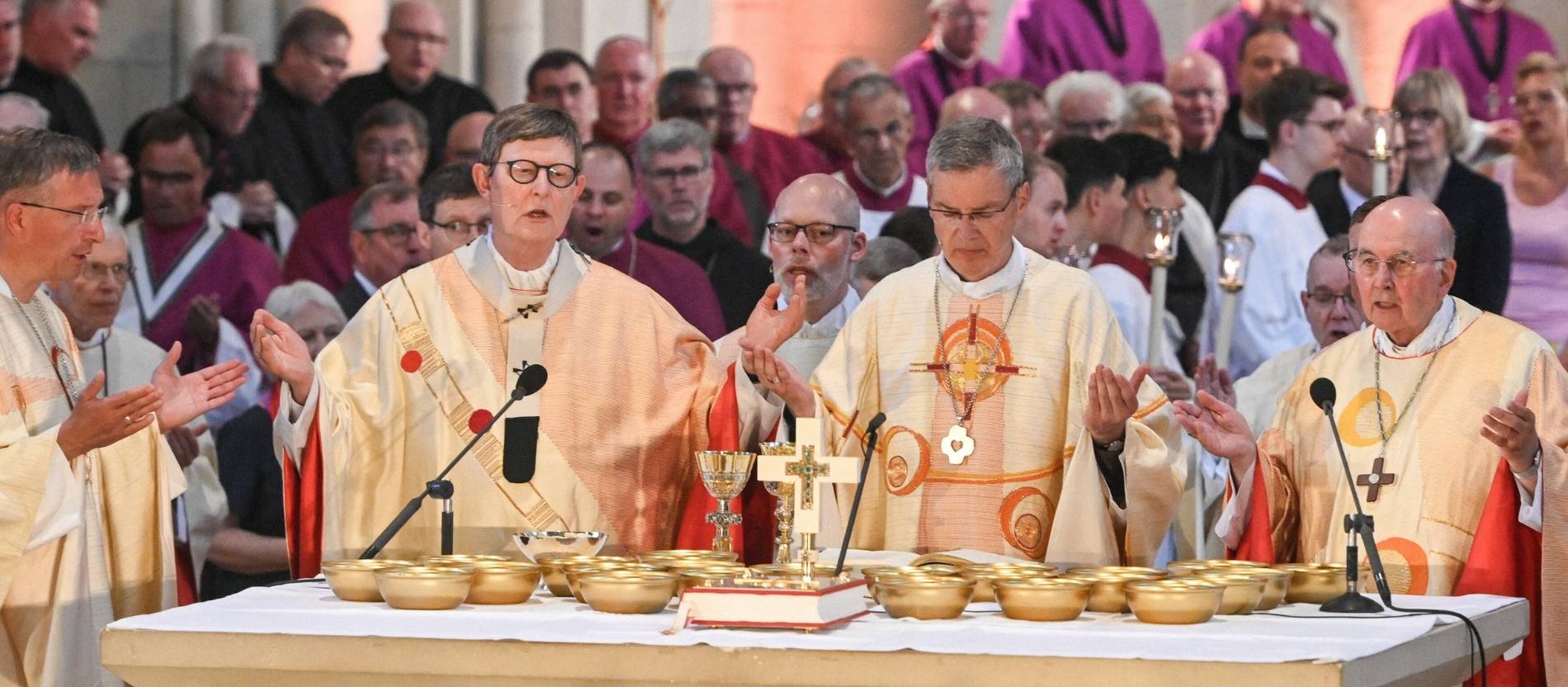 Kardinal Rainer Maria Woelki und Bischof Heiner Wilmer stehen zusammen am Altar