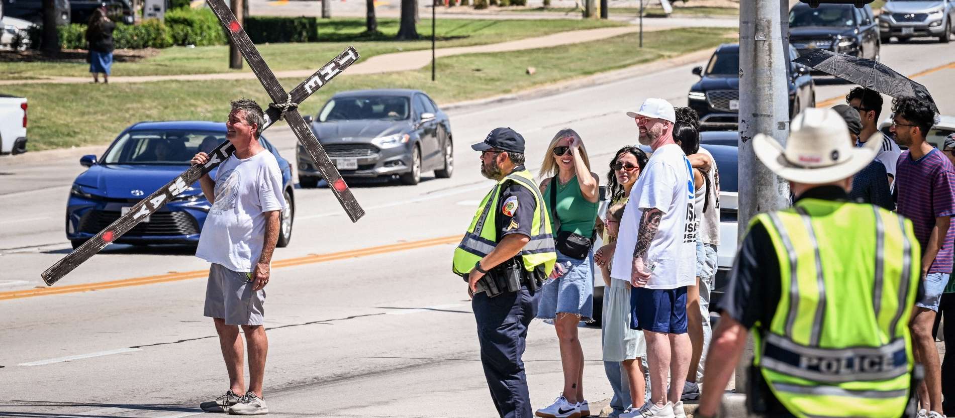 Ein Mann trägt ein großes Holzkreuz am Rande eines Spiels der Fußball-Weltmeisterschaft in den USA