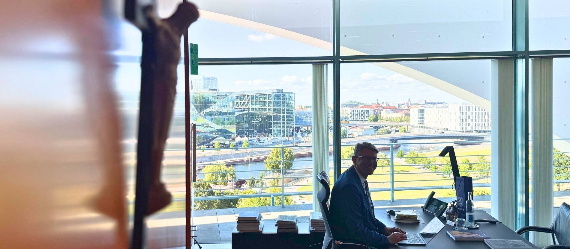 Kulturstaatsminister Wolfram Weimer sitzt in seinem Büro, im Vordergrund ein Kruzifix