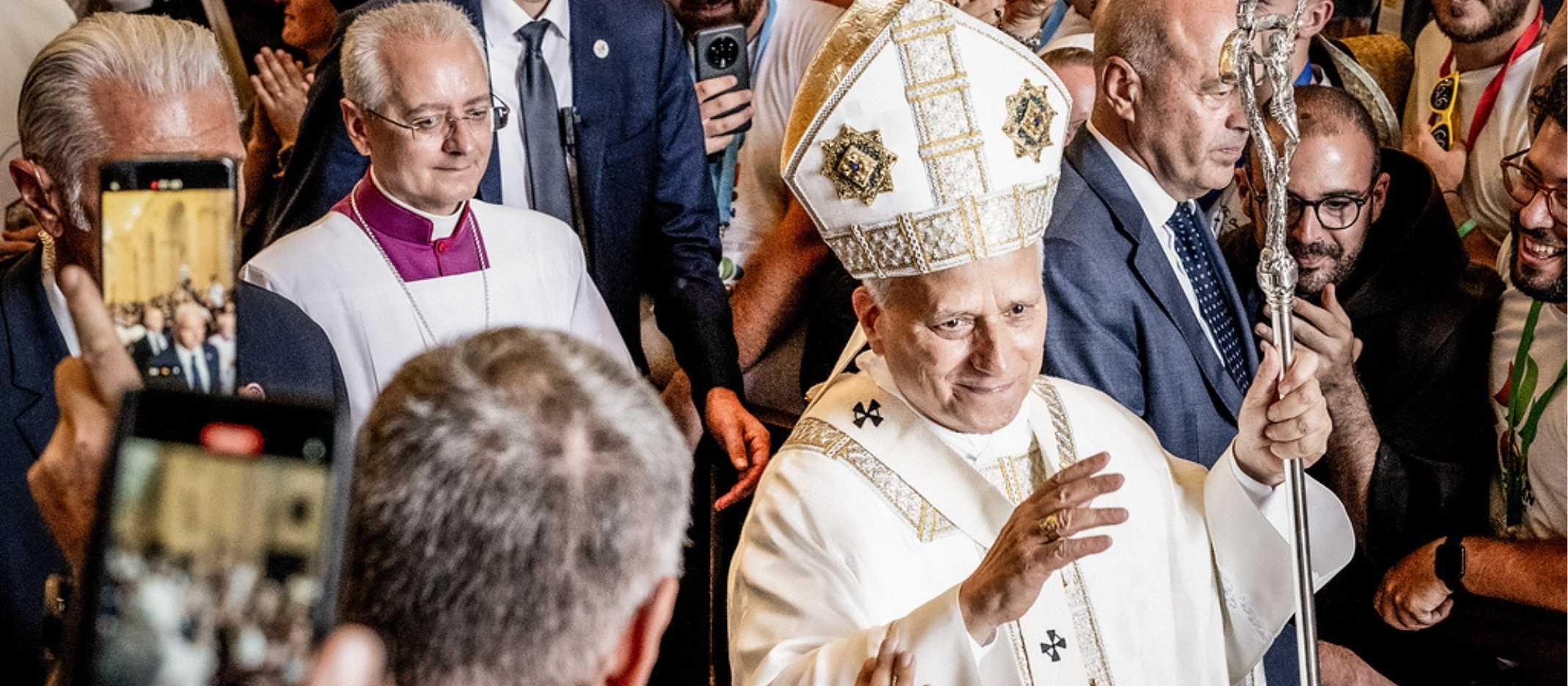 Papst Leo läuft durch die Kirche. Viele Handy sind auf ihn gerichtet. 