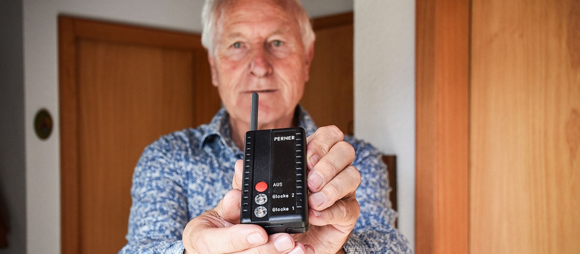 Walter Biberacher hält eine Fernbedienung in der Hand.