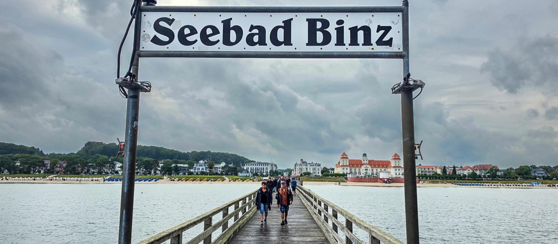 Ein Schild mit der Aufschrift "Seebad Binz" auf einem Steg. 