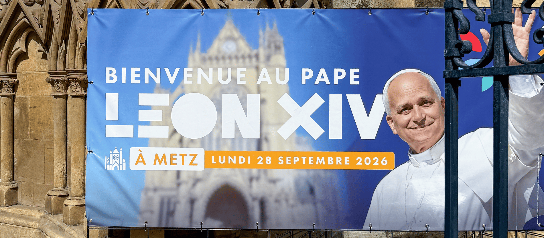 Ein Plakat zum Papstbesuch in Metz, auf dem Papst Leo winkt.