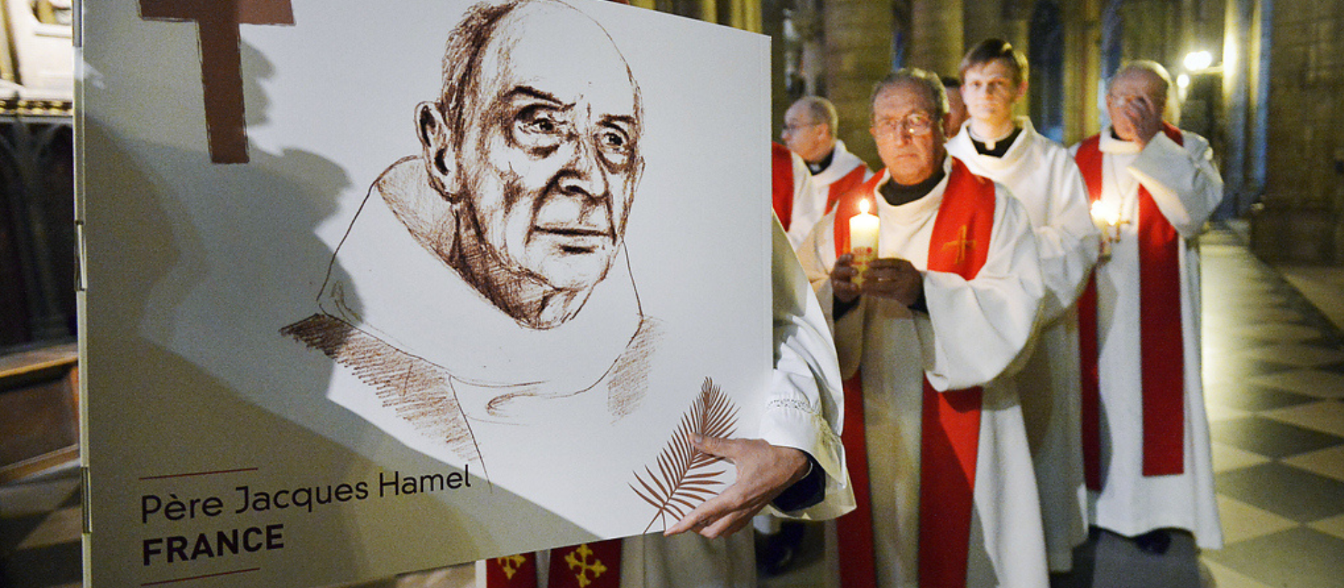 Priester tragen eine Zeichnung mit dem Abbild des ermordeten Priesters Jacques Hamel