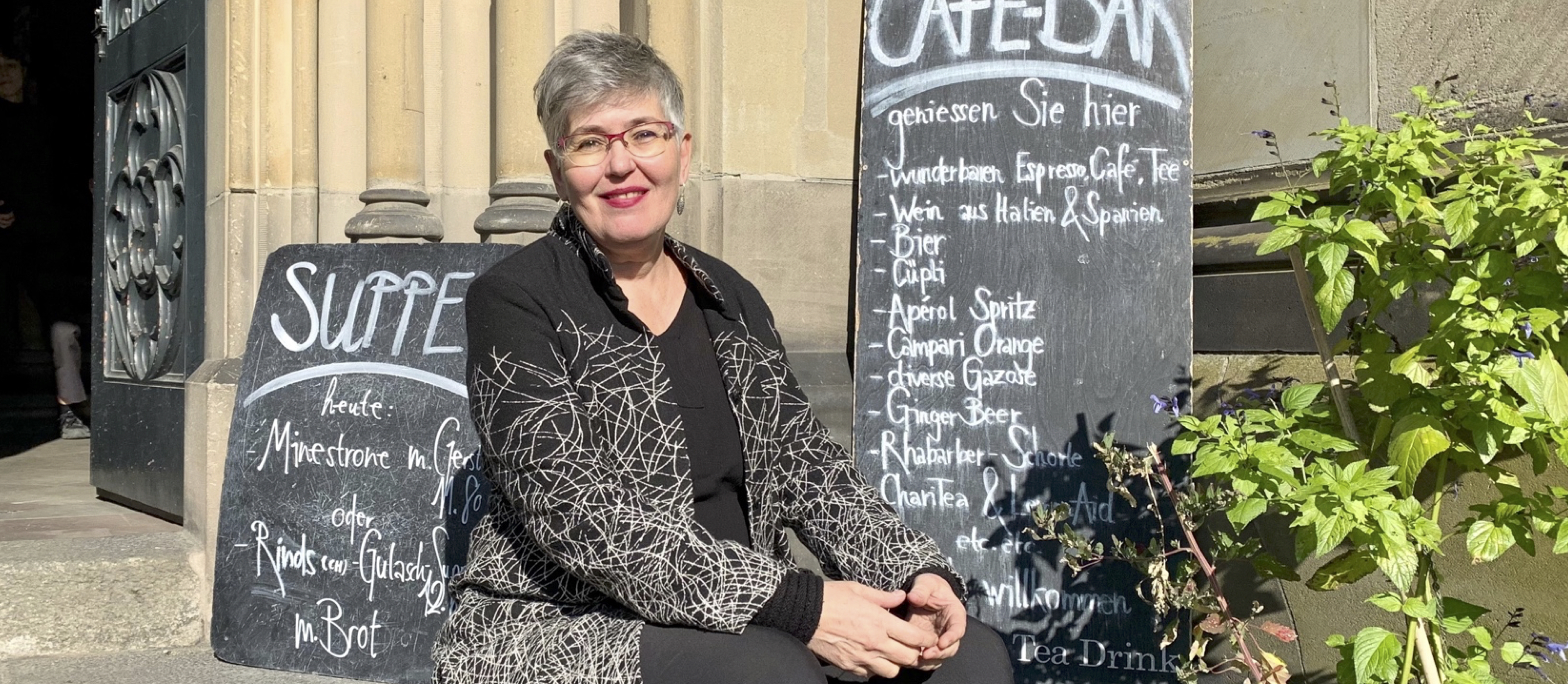 Monika Hungerbühler sitzt auf den Stufen des Kirchencafés