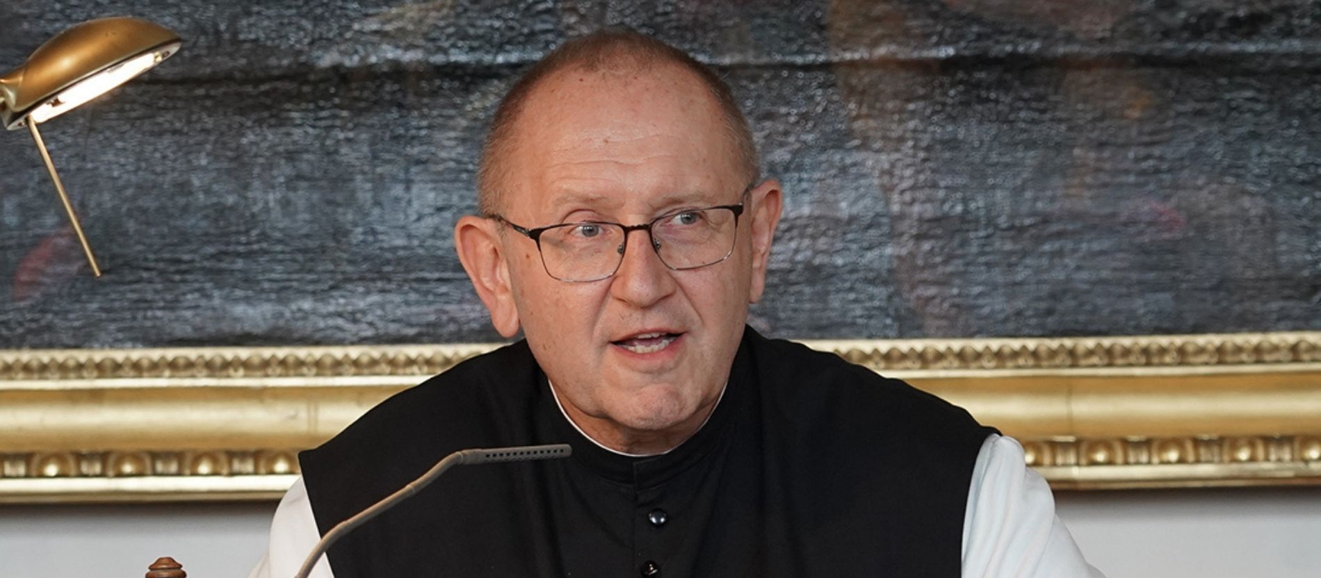 Pater Karl Wallner spricht in ein Mikrofon