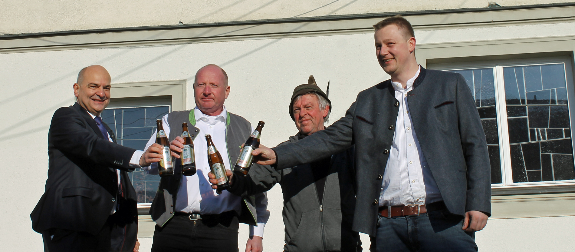 Vier Männer stoßen mit dem Respekt-Bier der Drachselrieder Schlossbrauerei an