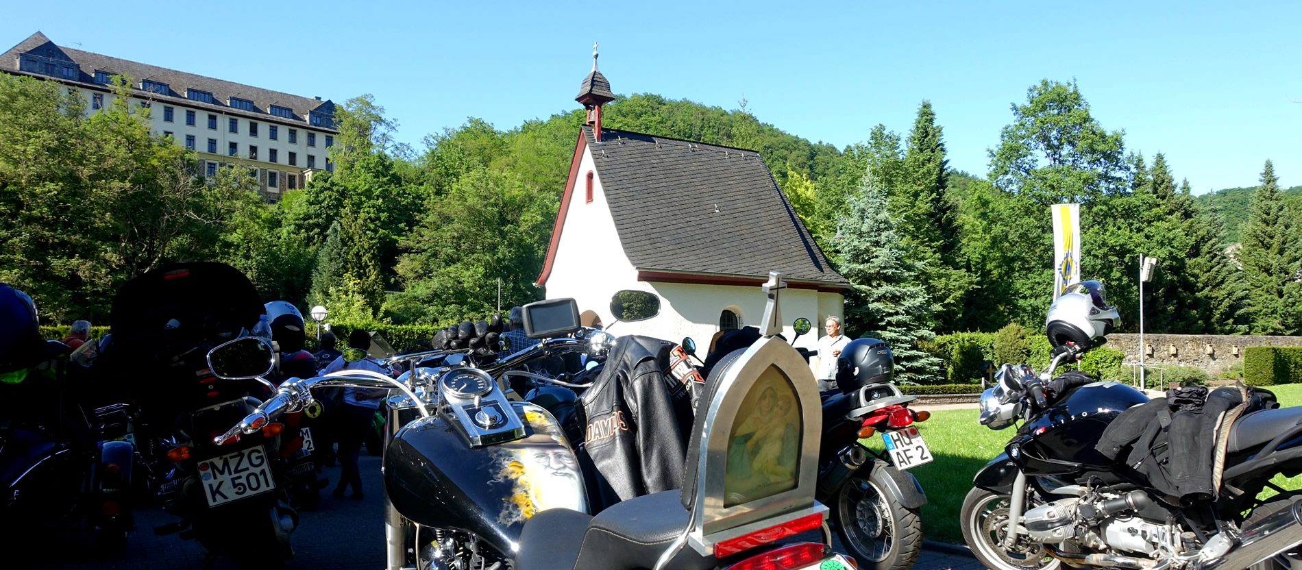 Eine Harley Davidson mit einer Marienfigut am Gepäckträger und einem Bild des Schönstatt-Gründers Pater Kentenich. 