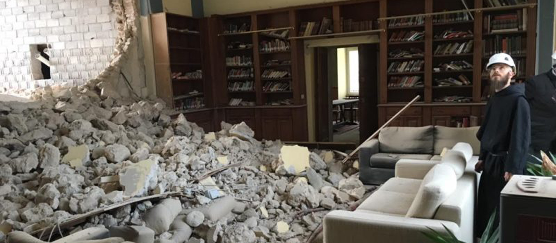 Ein Mönch begutachtet eine Wand der Kloster-Bibliothek, die eingestürzt ist.