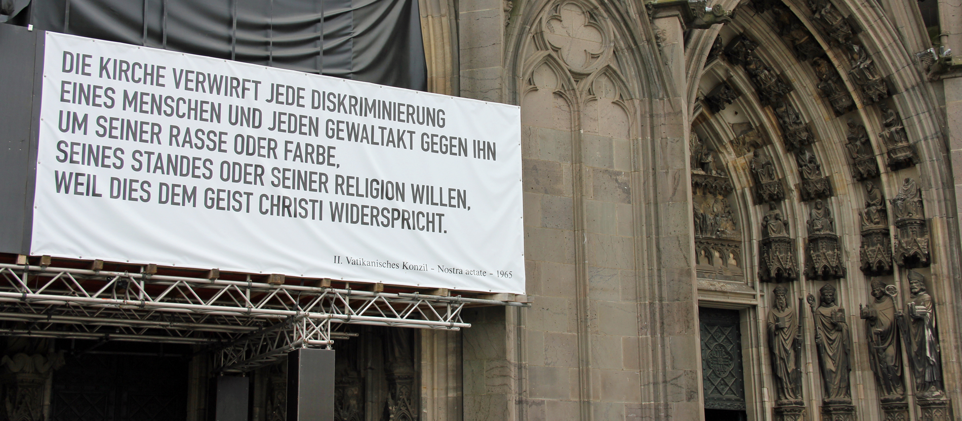 Plakat zu Nostra aetate hängt am Kölner Dom