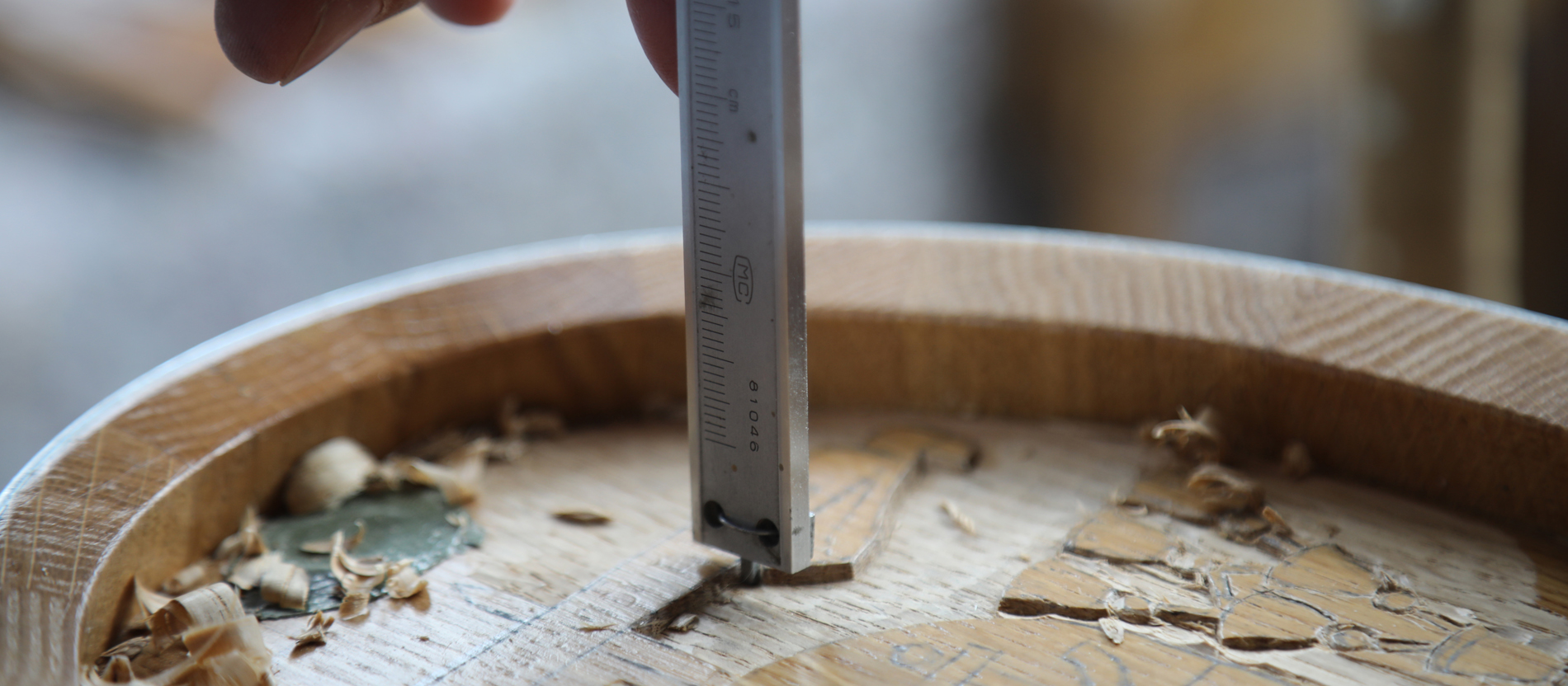 Maximal vier Millimeter darf die Schniterei ins Holz eindringen, damit das Fässchen nicht undicht wird. Regelmäßig überprüft der Schnitzer daher seine Arbeit.