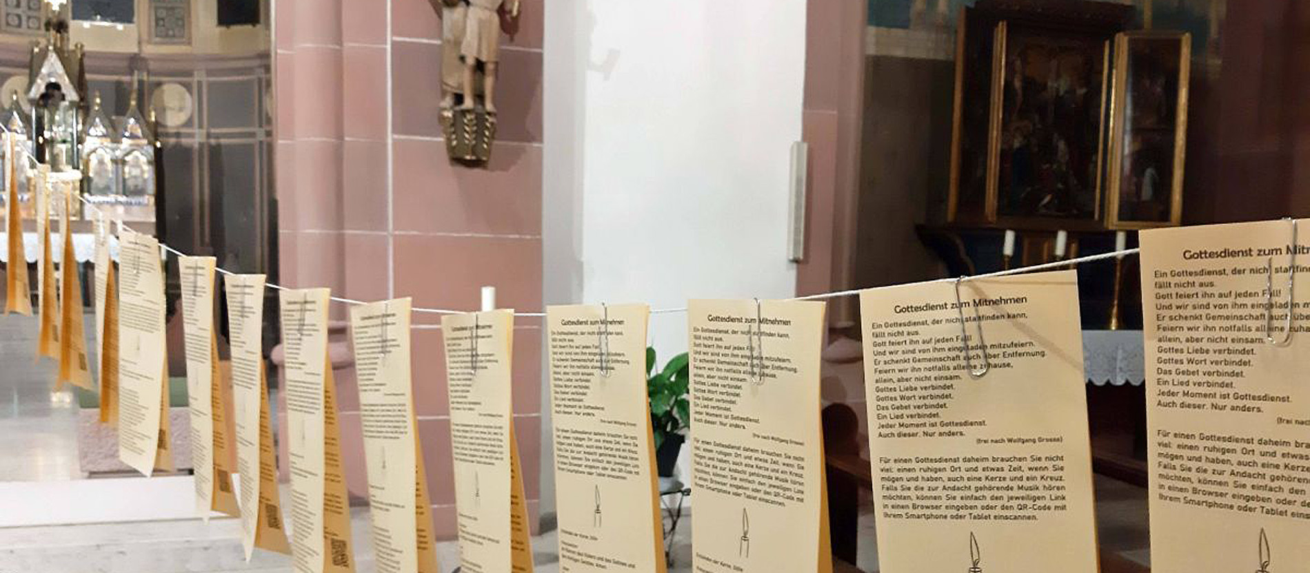 Zettel sind an einer Leine durch den Kirchenraum gespannt.