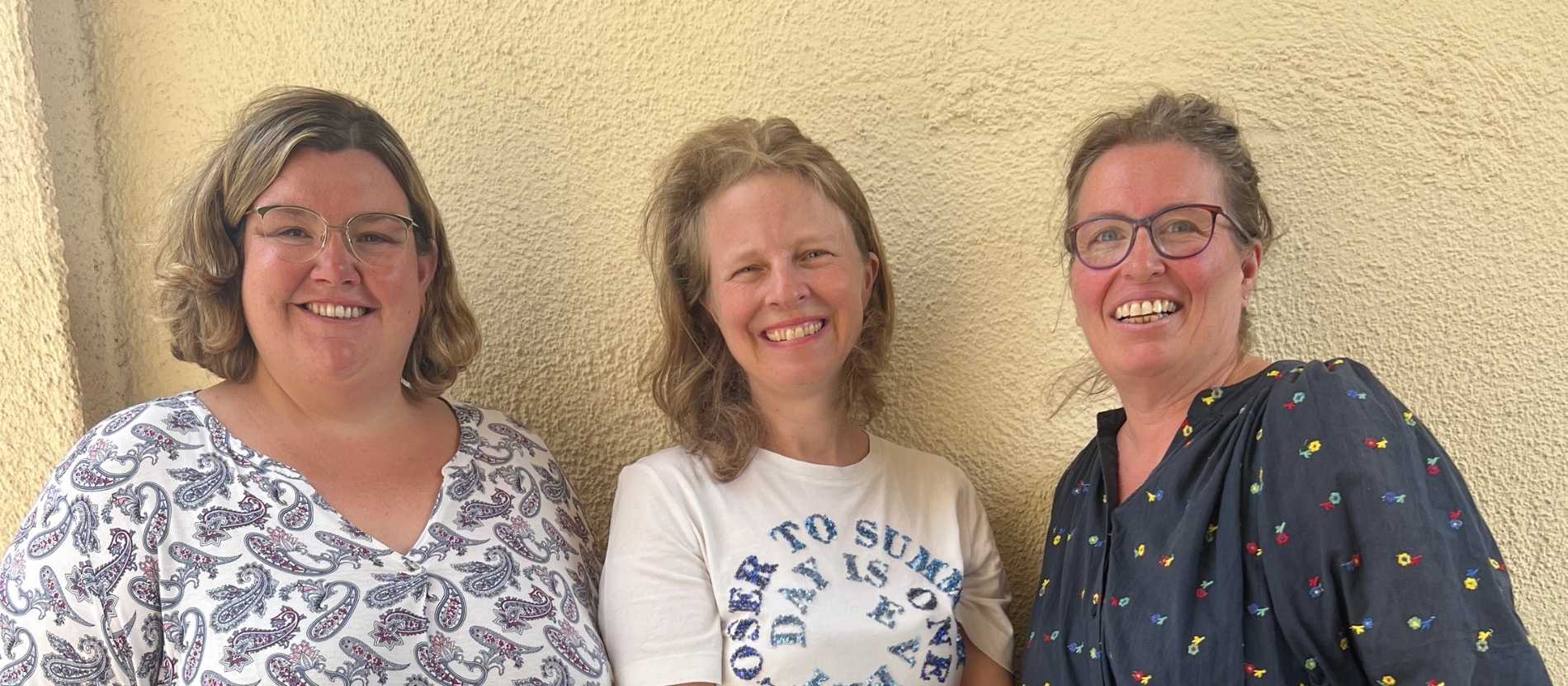 Drei Frauen lächeln in die Kamera