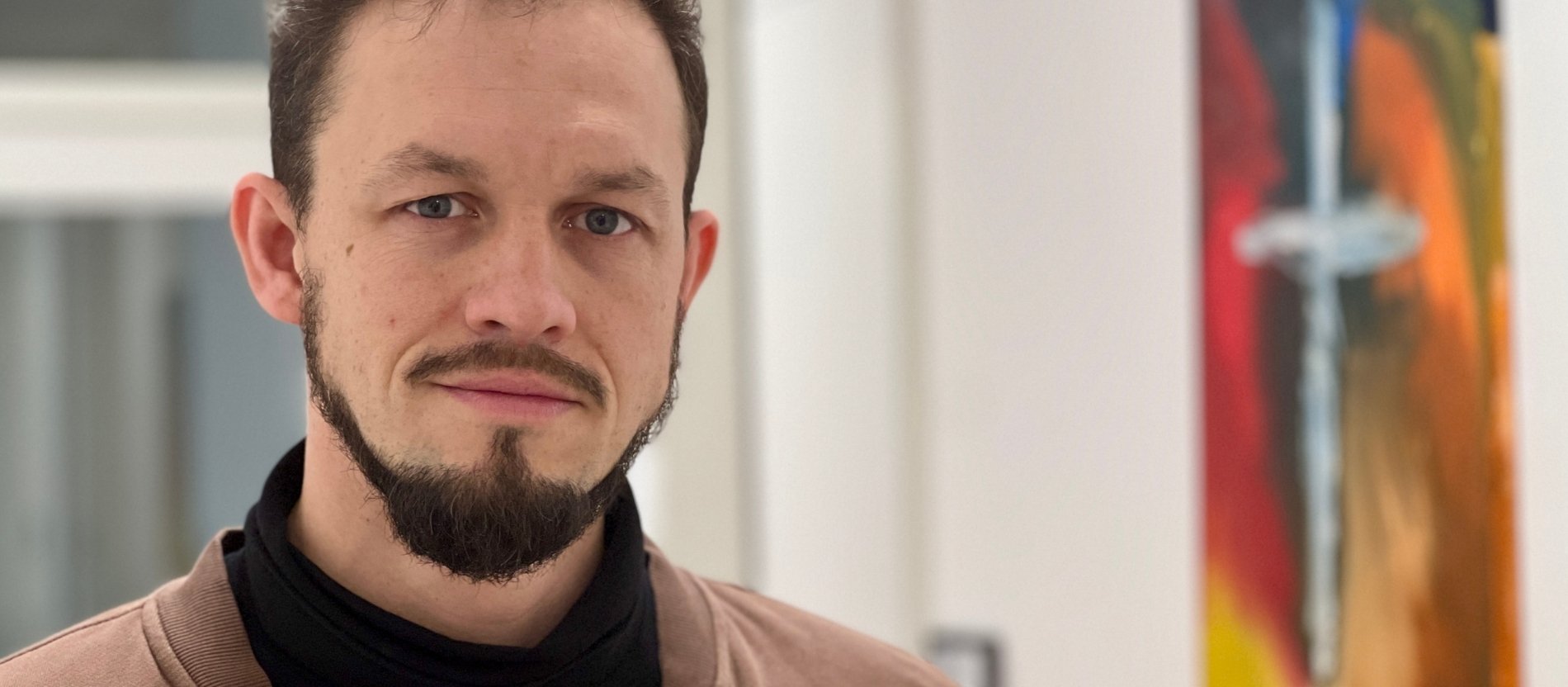 Der Gemeindereferent und Diakon Nick Pfeiffer steht in einem Raum.