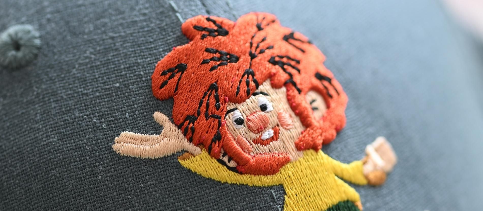 Nahaufnahme der gestickten Pumuckl-Figur auf einer Kappe
