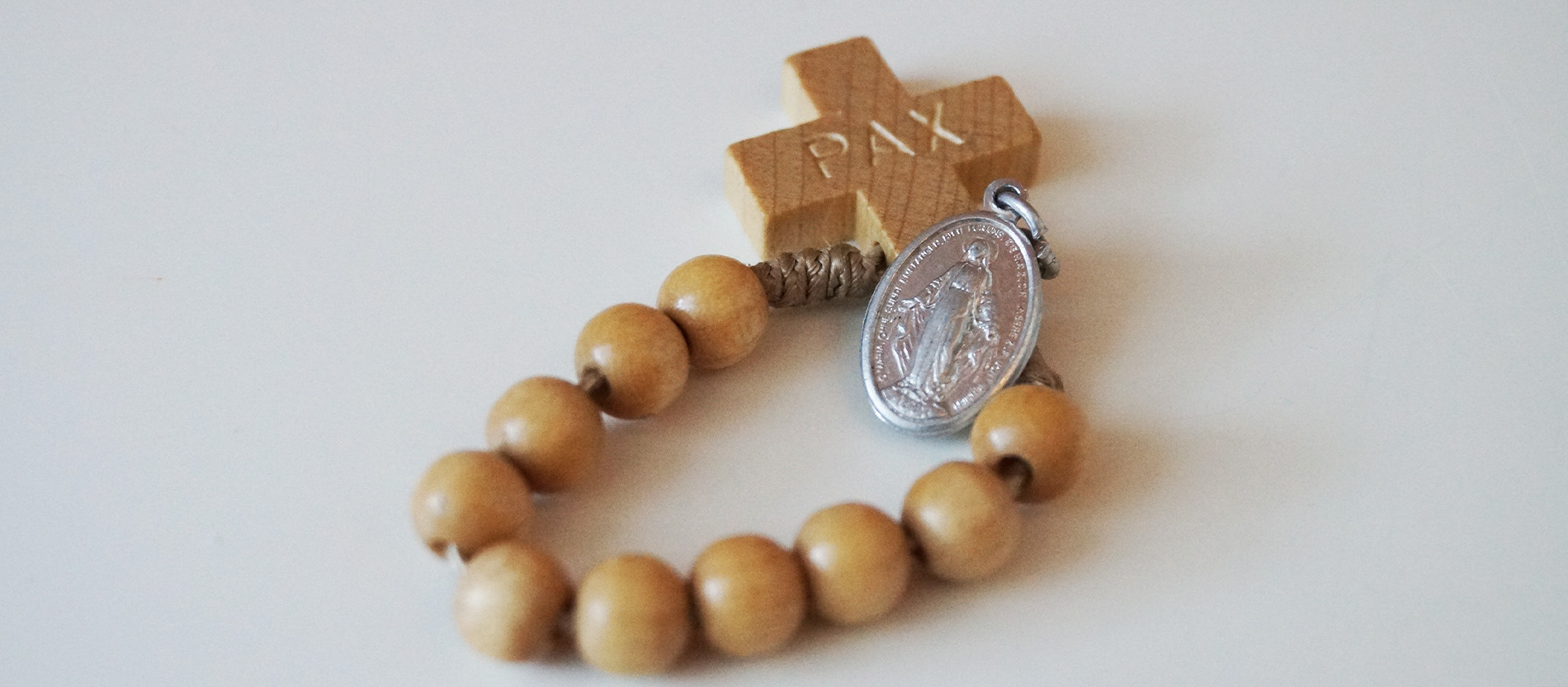 Ein Rosenkranz mit 10 Holzperlen und einem Bild der Muttergottes Maria.
